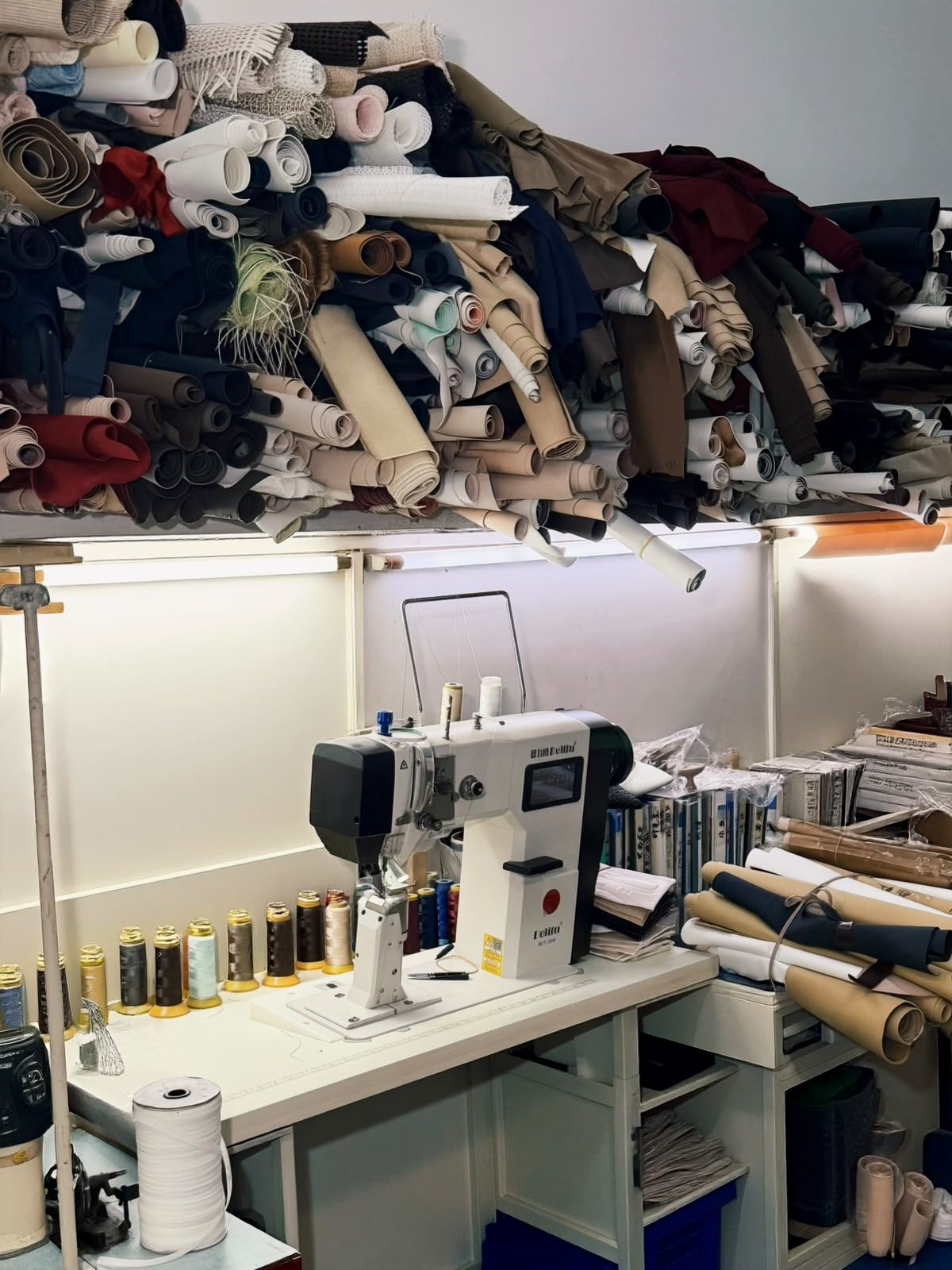 Rouleaux de matières au-dessus d'un poste de couture