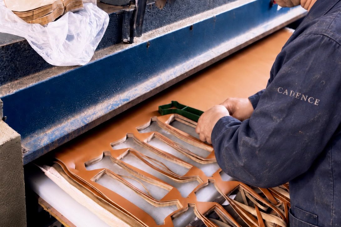 Artisan découpant les pièces d'une chaussure à l'emporte-pièce