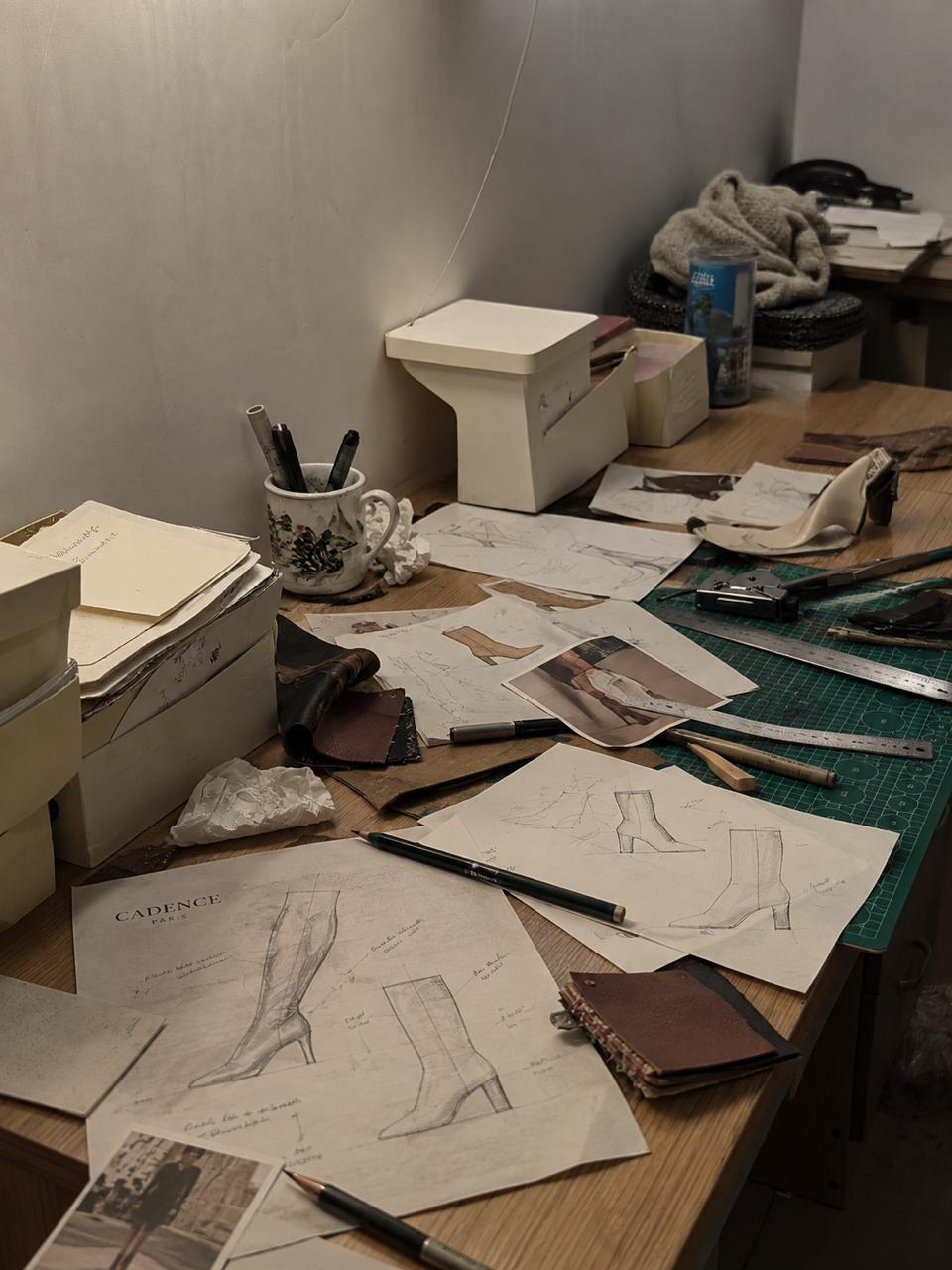 Table de création : croquis de bottes, patrons et échantillons de matières